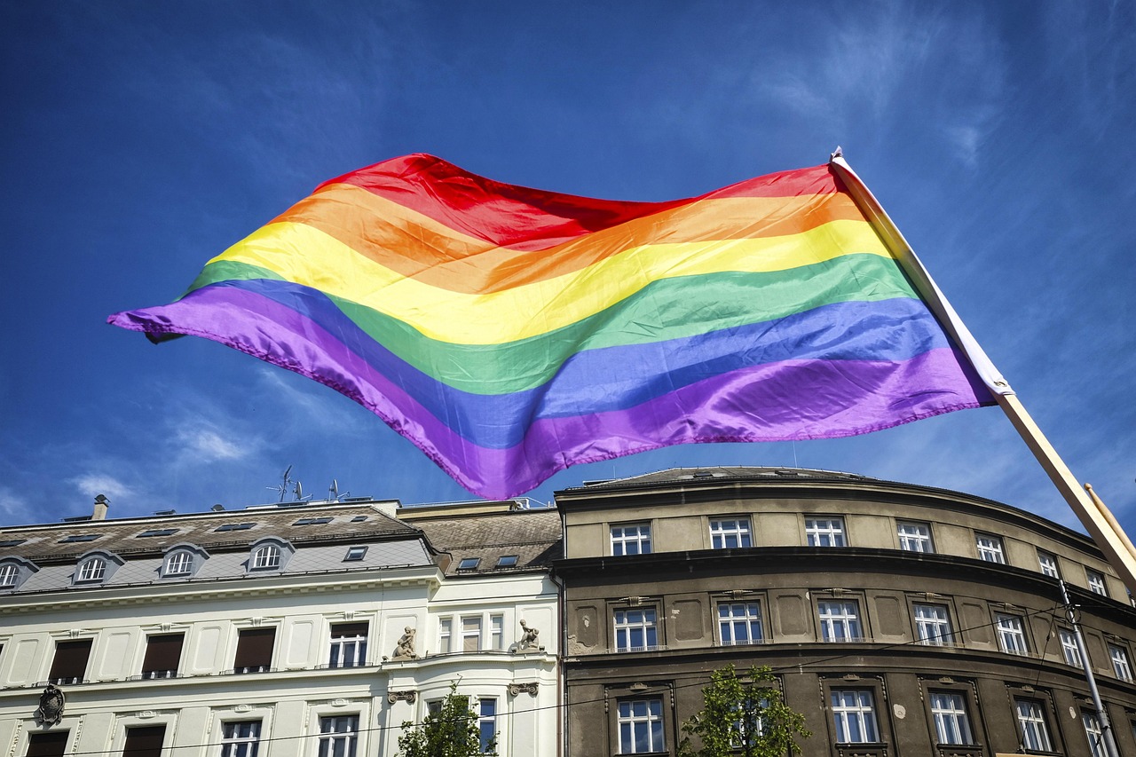 Regenboogvlag boven een Europese straat; illustratief beeld