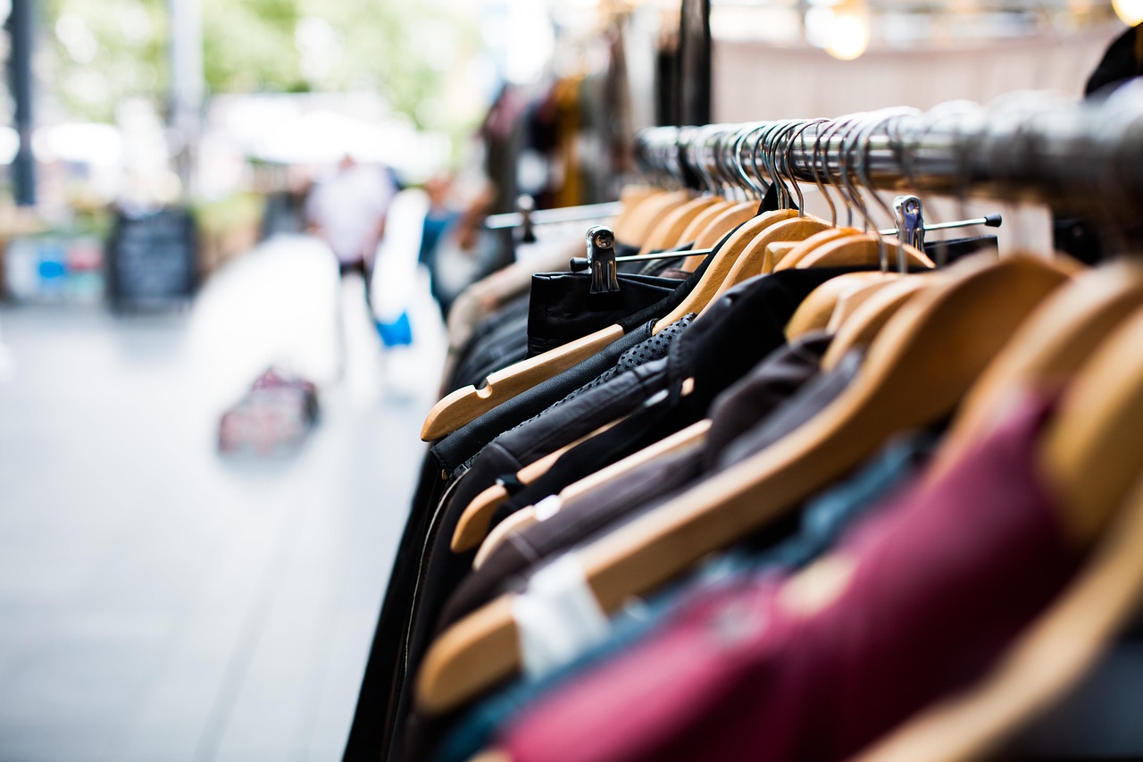 Kleding aan hangers in een winkel; illustratief beeld